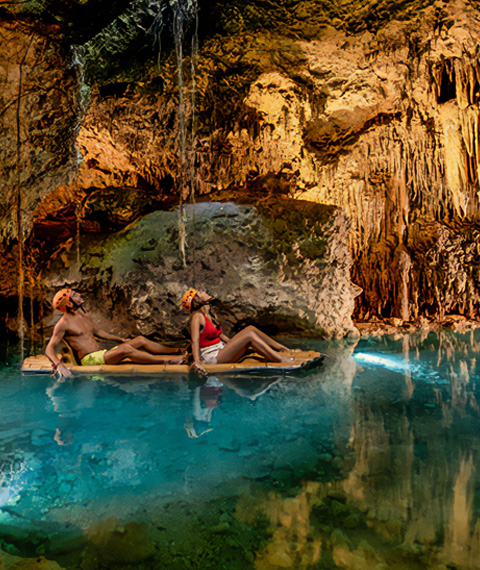 Floating through an underground river cavern on a raft at Xplor